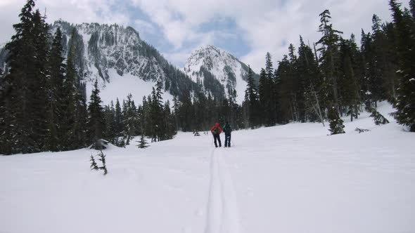 Dramatic Winter Adventure Background Of Hikers Looking Up At Mountains alt
