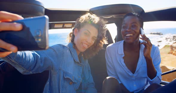 Female friends taking selfie with mobile phone 4k alt