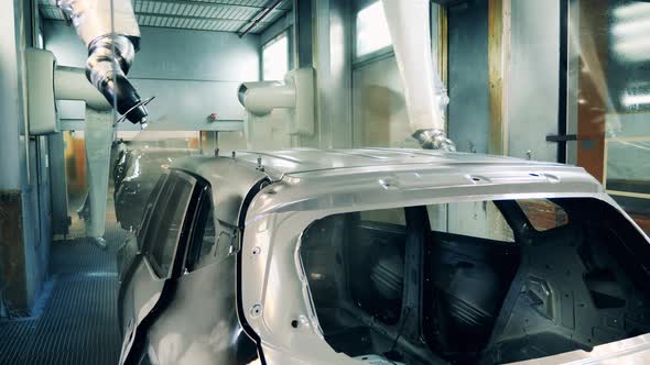 Robots Spraying a Car Body on an Factory Assembly Line alt