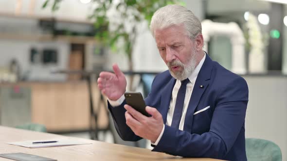 Sad Senior Old Businessman Having Failure on Smartphone alt