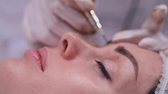 Side Closeup of a Girl Who is on the Procedure of Permanent Makeup alt