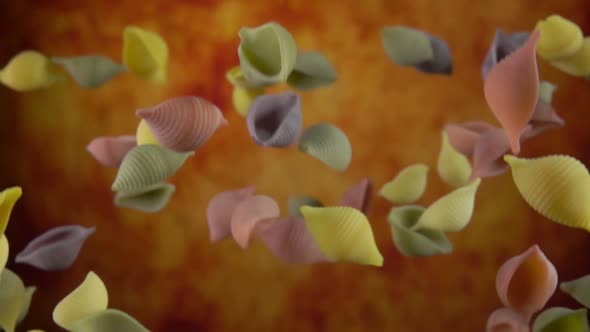 Colored Pasta Conchiglie is Flying Up on a Yellow Ochre Background alt