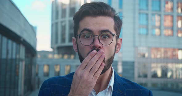 A Shocked Man with Glasses and Shirt Saying Wow Cover your Mouth with your Hand alt