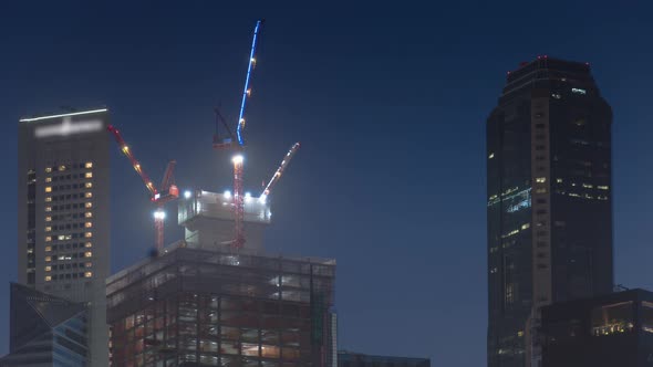 Aerial view of skyscrapers under construction with huge cranes timelapse. alt