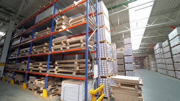 Shelves of warehouse are filled with parquet. Stock of woodworking factory. alt