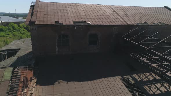 Aerial view of old red brick factory with an iron roof next to the river 32 alt