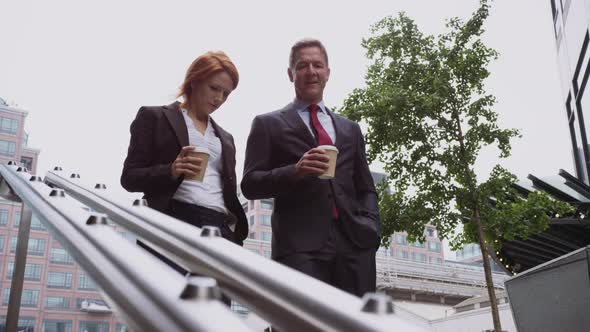 Businessman and businesswoman discussing work on the move