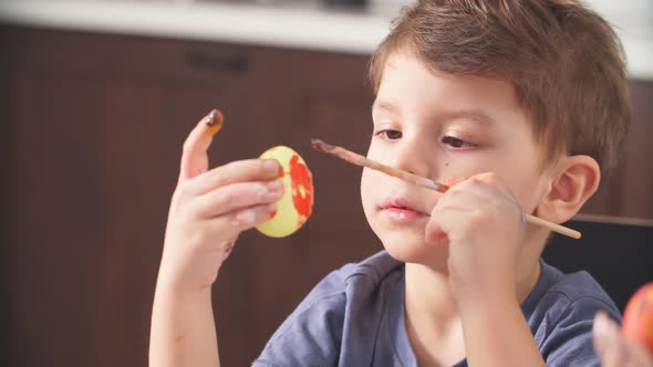 Little Boy Decorating Easter Eggs for Holiday alt