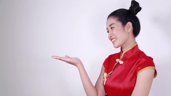 woman wear red cheongsam with open hand palm in concept of happy chinese new year alt