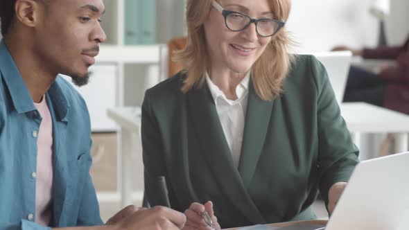 Middle-Aged Female Mentor Training Young Black Office Intern alt