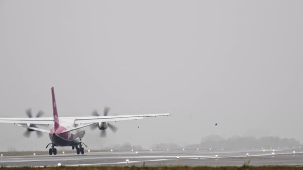 The Plane Travels on the Runway in Rainy Weather alt
