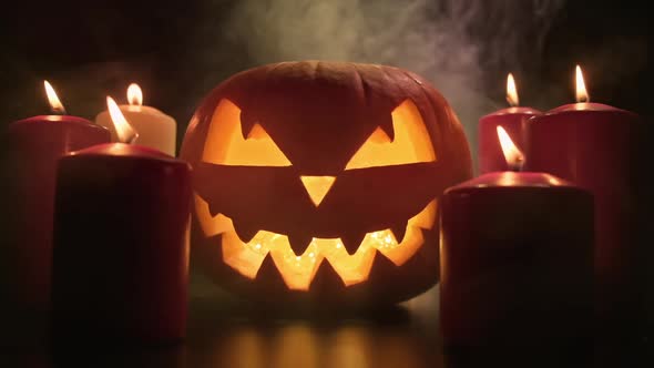 Scary Glowing Face of Halloween Pumpkin with Smoke alt