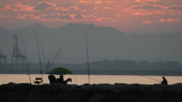 Fishers Fishing in the Rocks at Sunset alt