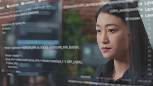 Portrait of Focused Asian Software Developer Through Vfx of Floating Programming Code alt