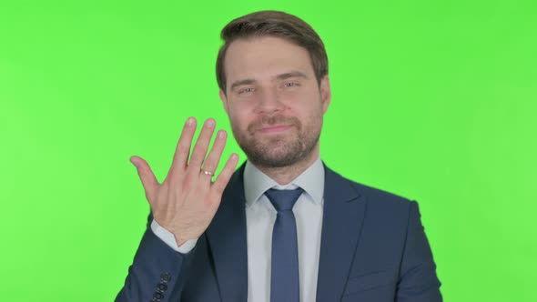 Happy Young Businessman showing Marriage Ring on Finger on Green Background alt