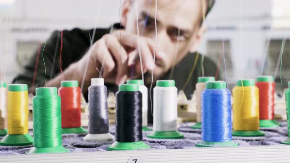 Man in a Fabric Factory Checking the Sewing Thread alt