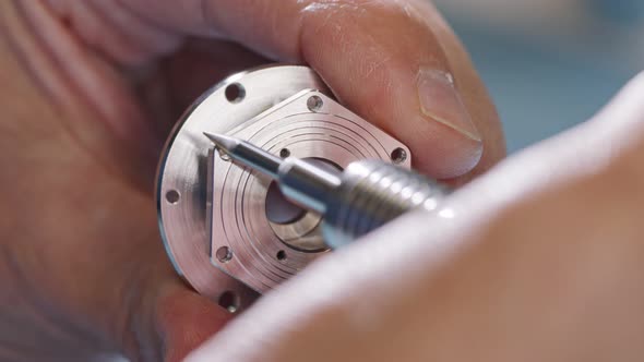 Close up on worker hands during metal part finishing process alt