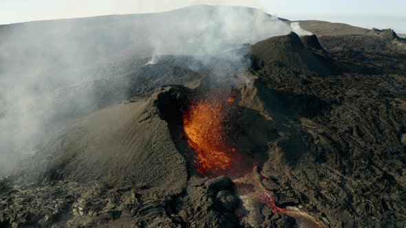 Orbiting Geldingadalir Volcano crater, burning and spewing fountain of hot lava during sunlight. alt
