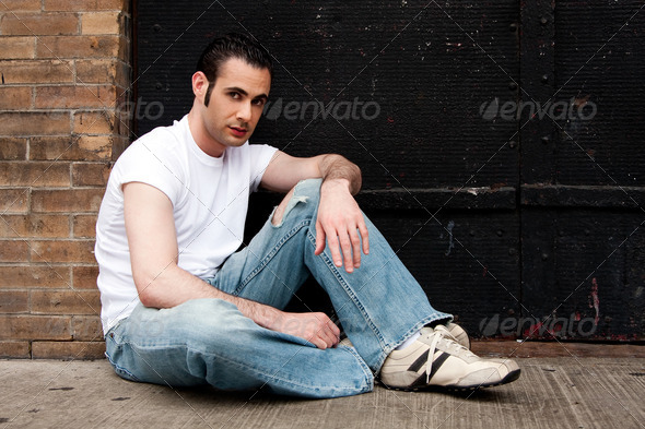Man sitting on concrete - Stock Photo - Images