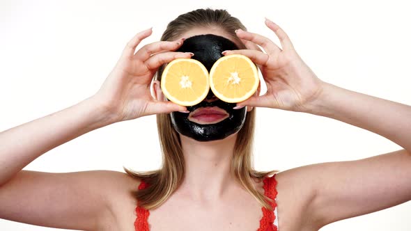 Girl Black Facial Mask Holds Orange Fruits