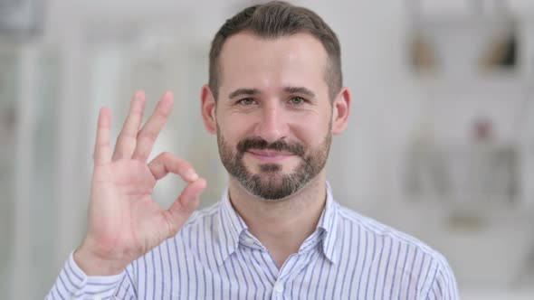 Portrait of Young Man Showing Okay Sign By Hand  alt