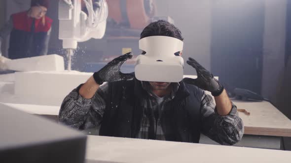 Craftsman in VR Goggles Working with Plastic Block alt