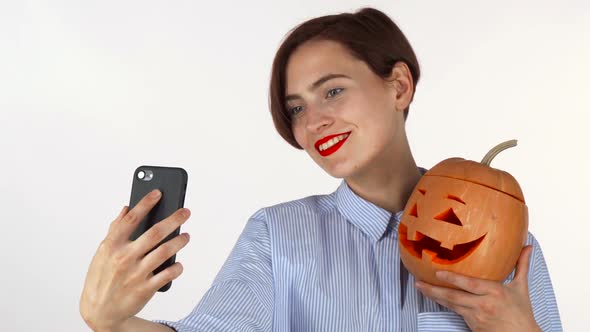 Beautiful Young Woman Taking Selfies with Halloween Pumpkin alt