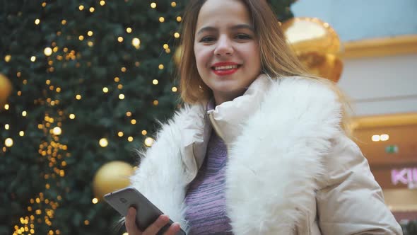 Young Beautiful Girl with Phone in Her Hands