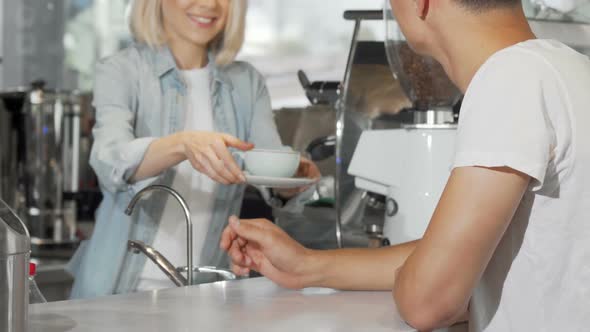 Cropped Shot of a Man Taking Cup of Coffee From Female Barista