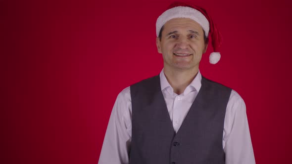 Man in Santa Hat Catching Flying Gift Box, Christmas Wreath Falls on His Neck