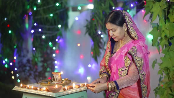 A Women Lighting a Lamp