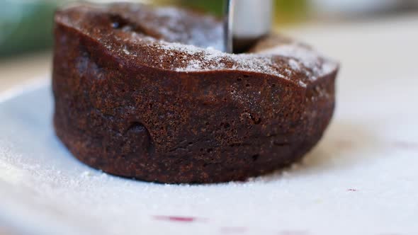 Women eating chocolate cake in a summer cafe. Liquid chocolate flows smoothly out of the cake alt
