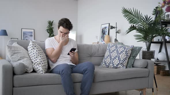 Tense Frustrated Man Reaction, while Using Smartphone alt