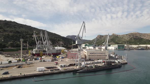 Aerial view of dockyard equipped with heavy duty cranes; submarine repairs