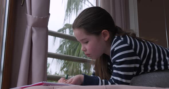 A Little Girl Drawing with Pencils at Home