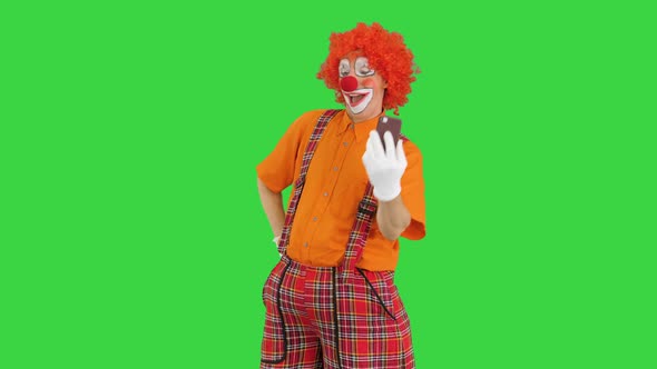 Clown Taking Selfie with His Phone on a Green Screen, Chroma Key. alt