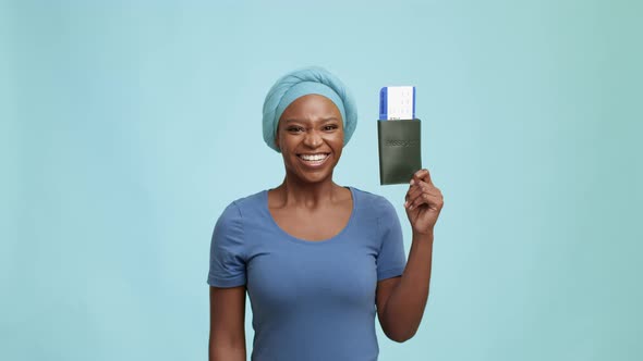 Joyful Black Woman Shaking Travel Tickets Holding Passport Blue Background alt