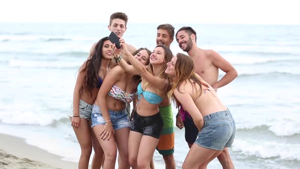 Multicultural group of friends taking a selfie at beach