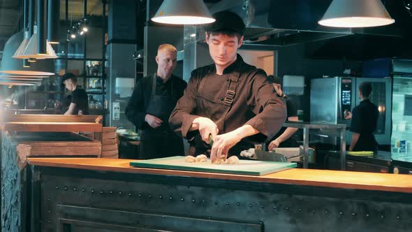 Restaurant Cook is Chopping Vegetables on the Cutting Board alt