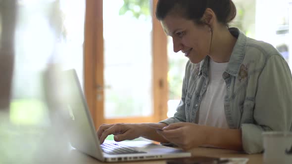 Woman using laptop at home alt