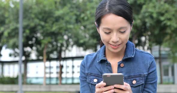 Woman using smart phone in city alt