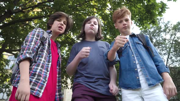 Bottom View of Violent Boys Frightening Victim. Portrait of Aggressive Caucasian Schoolboys Showing alt