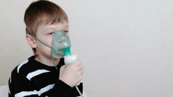 Using Nebulizer and Inhaler for the Treatment. Boy Inhaling Through Inhaler Mask