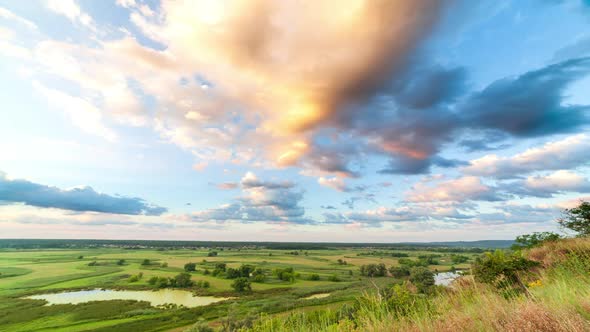 A Beautiful Valley with a River Blue Sky with Large Clouds and Bright Sun alt