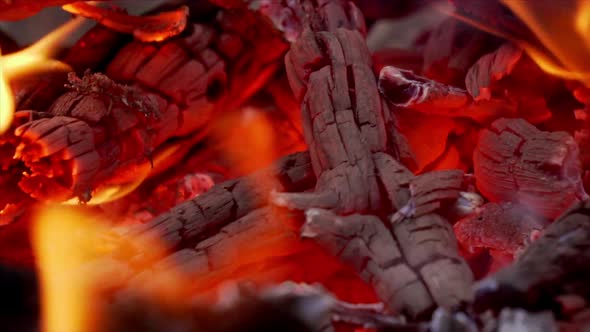 Close-up of a fire pit showing glowing red hot embers. alt