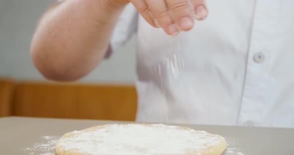 Sprinkling Flour on Dough Cake Close Up of Chef's Hand