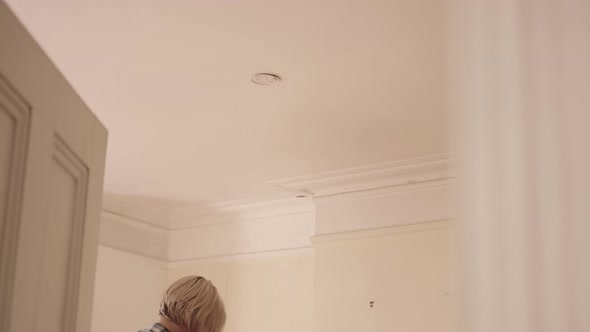 Adult Woman installing smoke detector in home