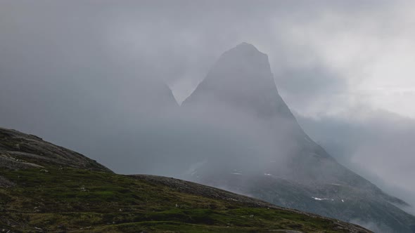 Timelapse Of White Fluffy Clouds Covering Rocky Mountain In Norway. - zoom out alt