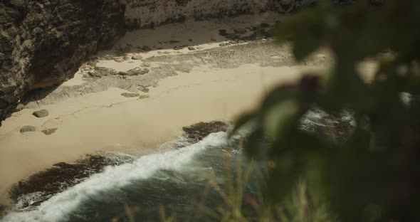Reveal of the Waves Slowly Crashing at the Stunning Rocky Tropical Sand Beach Surrounded By Cliffs alt