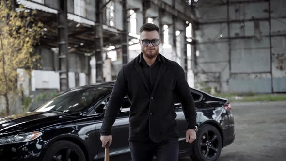 Strong man with a bat in abandoned place. alt